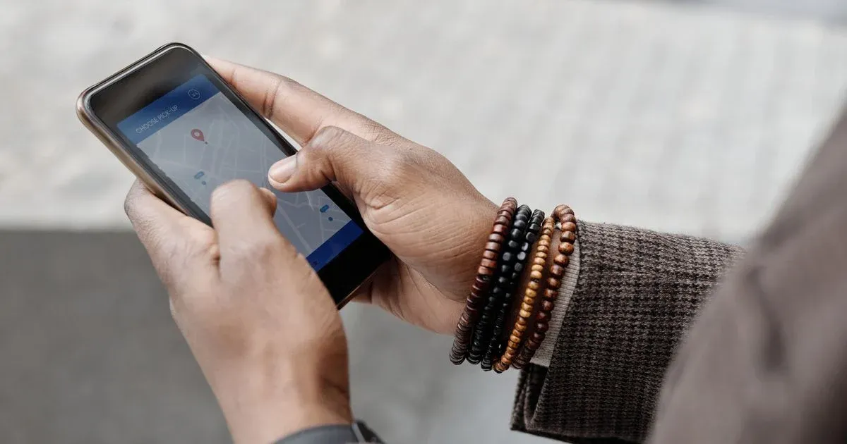 Hände halten ein Smartphone mit geöffneter Kartenansicht