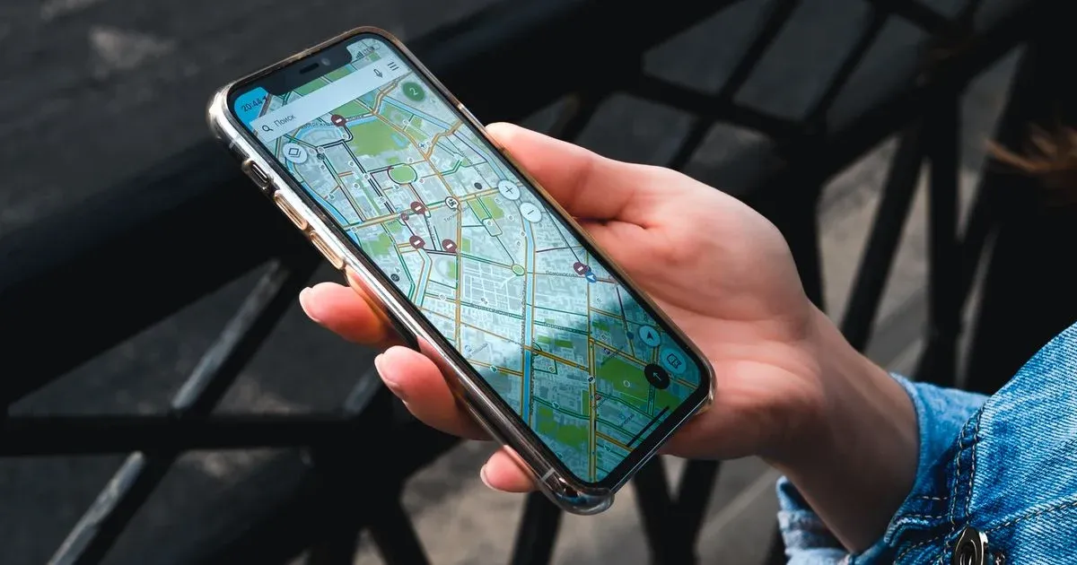 Mão segurando um celular com um mapa aberto na tela