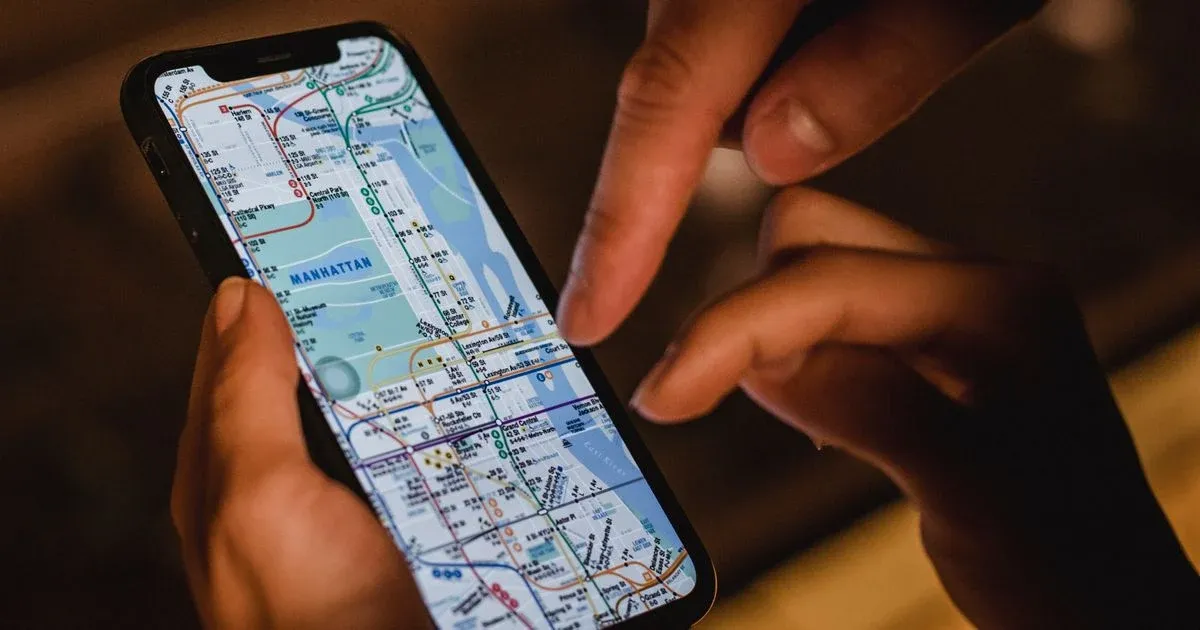 Mano che usa uno smartphone con una mappa della città sullo schermo